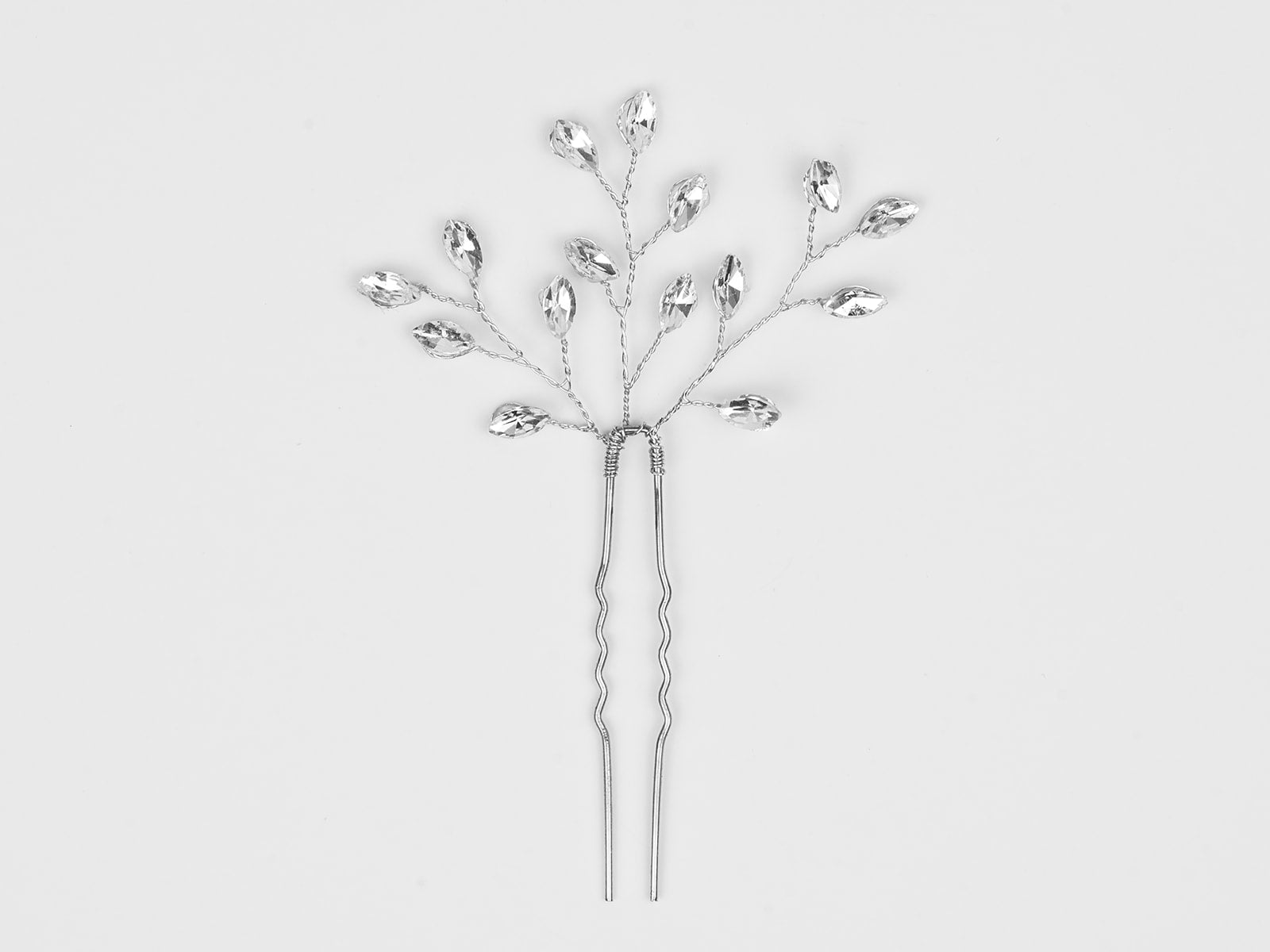 Silver hairpin with decorative elements on a light gray background