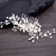 Decorative hair comb with pearls and crystals on a wooden surface