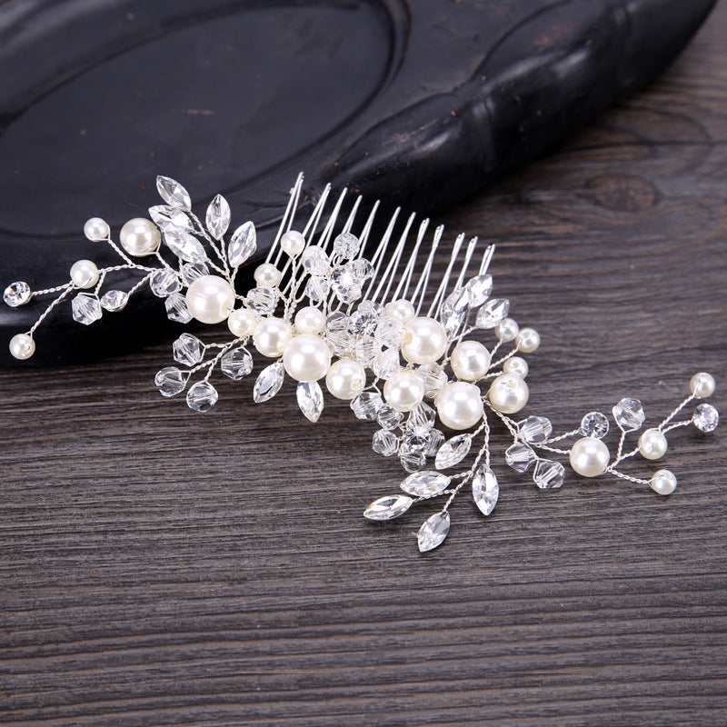 Decorative hair comb with pearls and crystals on a wooden surface