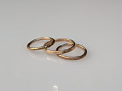 Three handmade brass stacking rings in hammered, textured and dotted finishes