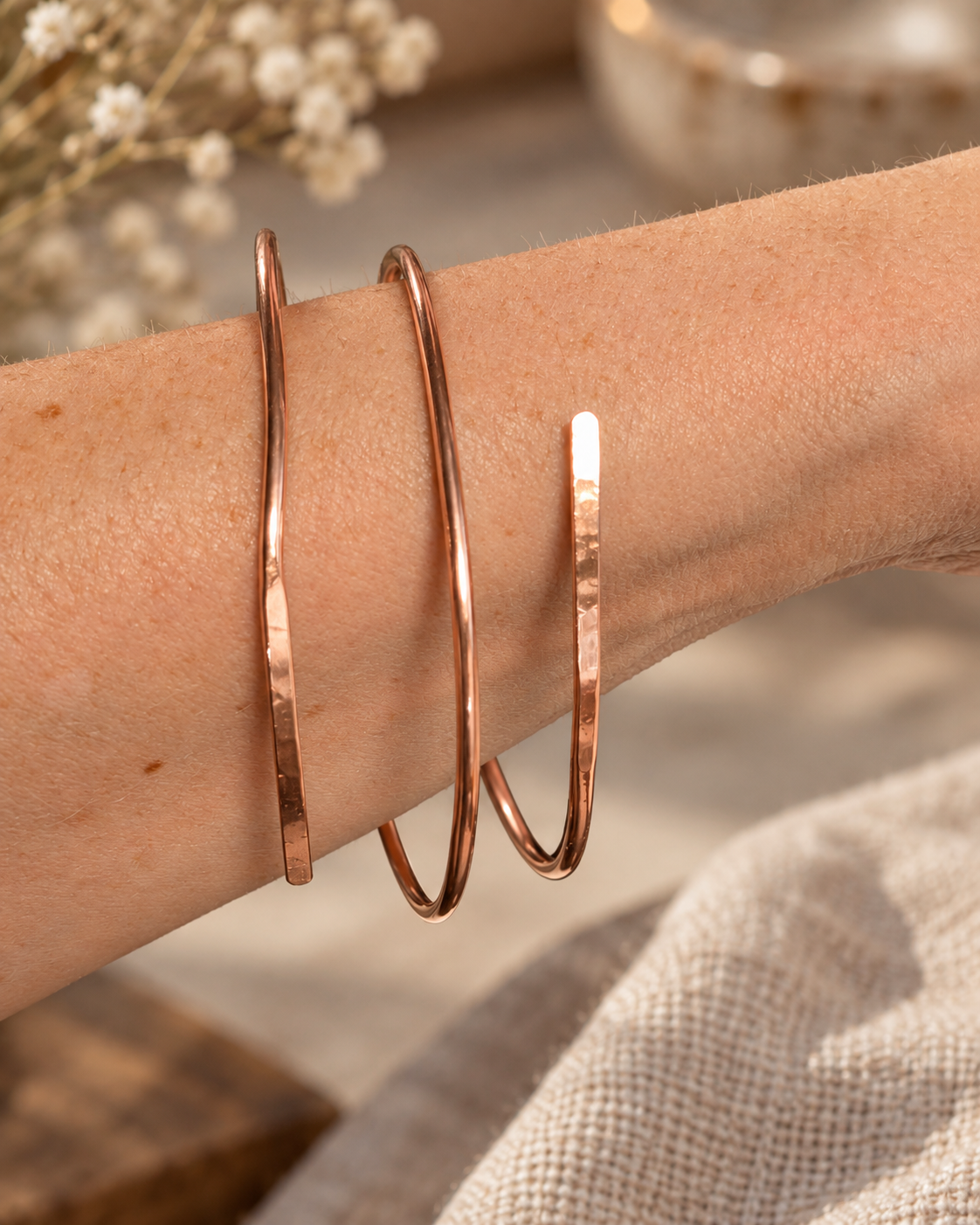 Handmade three-wrap open copper bangle worn on the wrist