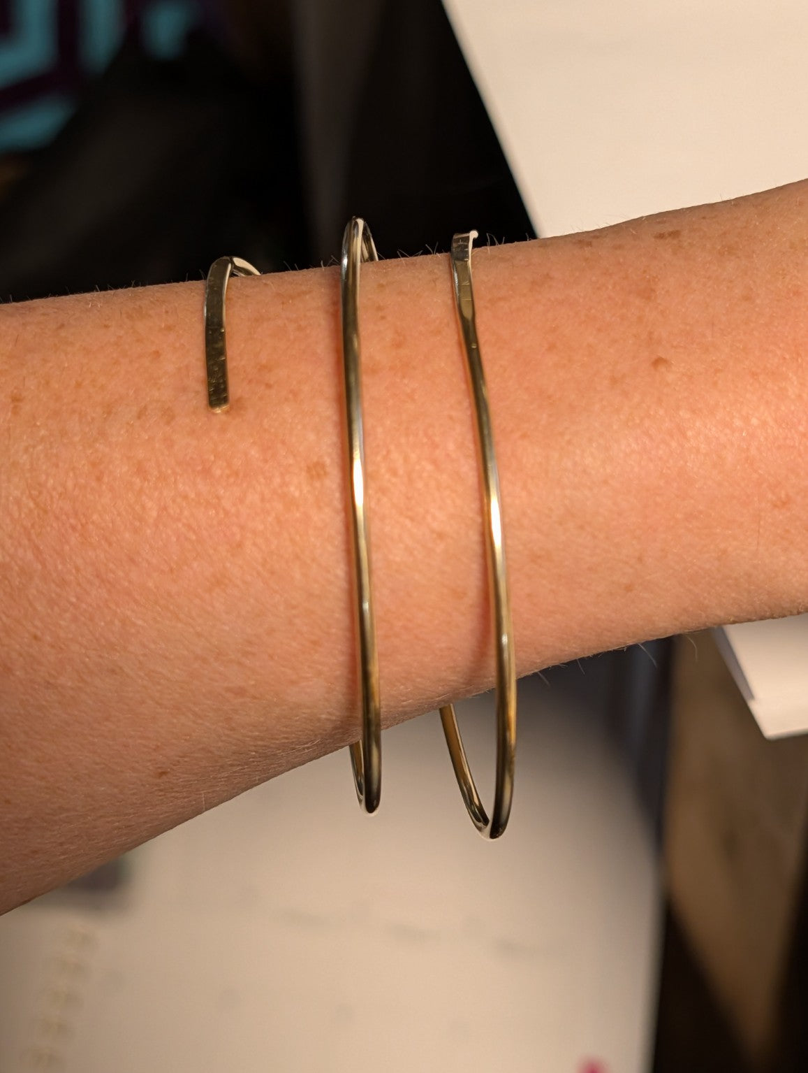 Handmade three-wrap open brass bangle worn on the wrist